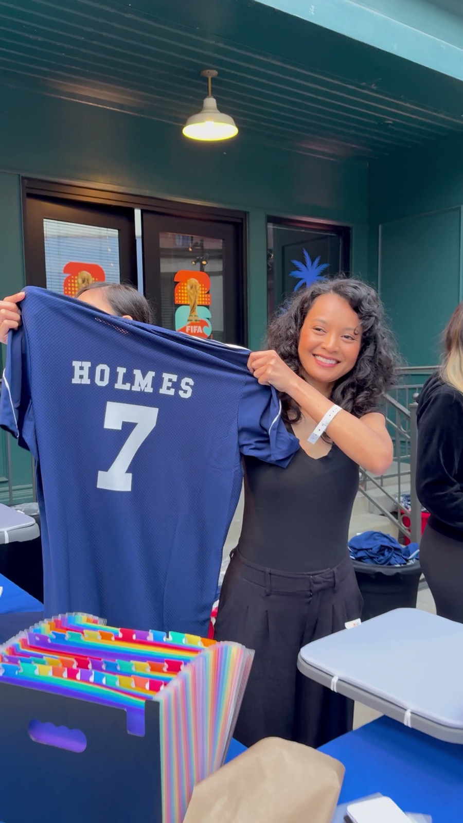 Guest holding up a navy jersey customized with her name minutes after requesting it